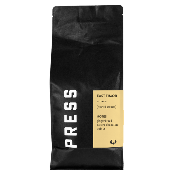 A black "PRESS" coffee bag with description written on yellow label.