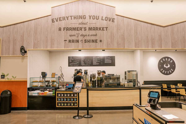 Press Coffee cafe in Sprouts Higley location. Press Coffee logo, coffee equipment, and a Press logo are on display. 