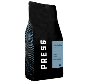 Black coffee bag with 'PRESS' branding and Colombia coffee details on a white background